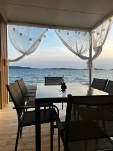 a table and chairs on a deck with a view of the ocean at Villa Kiara in Vodice