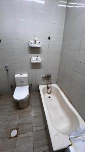 a bathroom with a toilet and a bath tub at Offer if booked at least 1 week Elegance Modern 1-Bedroom Close to Everything in Ajman  +3 photos