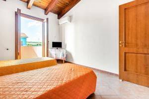 a room with two beds and a door with a window at Sweet Home in Portoscuso! in Piscinas
