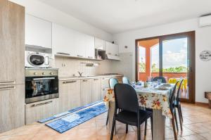 a kitchen with a table with chairs and a dining room at Sweet Home in Portoscuso! in Piscinas