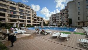 a courtyard with a pool and chairs and buildings at Relax in Sunny Beach in Sunny Beach