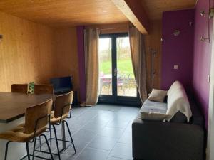 a living room with a table and a couch at Lodge détente et spa in Le Puley