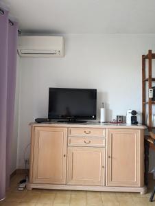 einen Fernseher auf einem Holzschrank in einem Zimmer in der Unterkunft Studio Calme Dernier Etage in Antibes