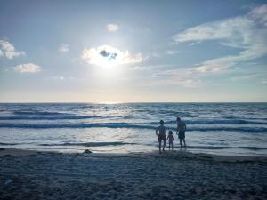 a group of three people standing on the beach at Reardi in Durrës