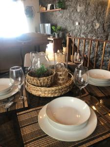 a table with plates and wine glasses on it at Vigia dos Machados in Lajes do Pico