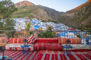 a view of the blue city of chefchaouen from a balcony with red at VANCII Hotel in Chefchaouene