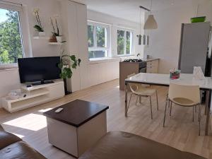 a living room with a couch and a table and a kitchen at NoAr Apartment Rijeka in Rijeka
