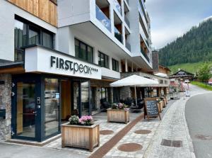 扎奥岑湖FIRSTpeak Zauchensee的街道上设有桌椅的建筑
