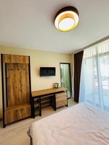 a bedroom with a bed and a desk with a television at Paradise Shekvetili in Shekhvetili +24 photos