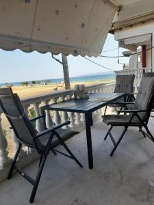 a table and chairs on a balcony with the beach at J&J Seaview Apartment in Ofrínion