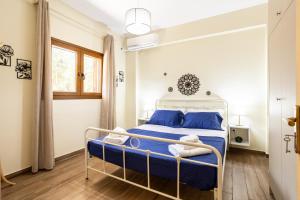 a bedroom with a bed with blue sheets and blue pillows at Nelly's Place Garden house 2 in Zakharo