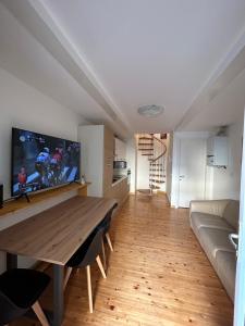 un soggiorno con un tavolo di legno e un divano di Appartamento centrale Housitaly a Lecco