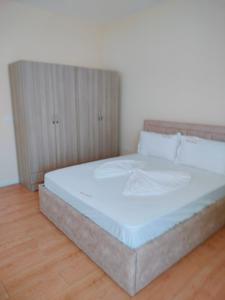 a bedroom with a large bed with white sheets at Reardi in Durrës +3 photos