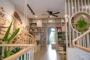 a home library with a spiral staircase and bookshelves at Sophia Healing House Cần Thơ in Can Tho