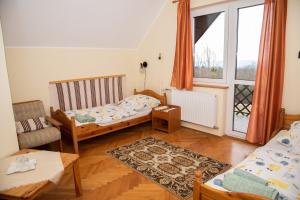 a small room with two beds and a window at Hubertus Vadászház in Újudvar
