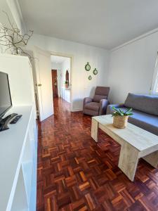 Una sala de estar con un sofá y una mesa de café. en Acogedor Apartamento, en Vilagarcía de Arousa