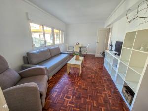 una sala de estar con un sofá y una mesa en Acogedor Apartamento, en Vilagarcía de Arousa