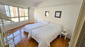 Un dormitorio con una cama grande con sábanas blancas. en Acogedor Apartamento, en Vilagarcía de Arousa