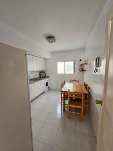 Una cocina y un comedor con mesa y sillas. en Acogedor Apartamento, en Vilagarcía de Arousa 3 fotos más