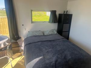 una camera da letto con un letto e una finestra di Adorable Tiny House in Reykjavik a Gufunes