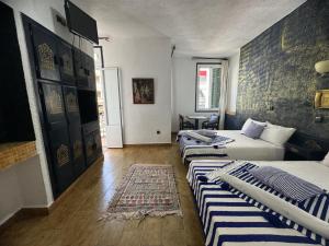 a bedroom with two beds and a rug at HOTEL REGINA in Tetouan