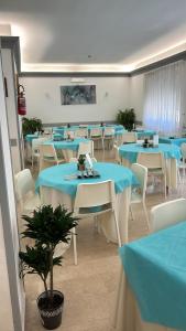 a dining room with blue tables and white chairs at Villa Angeli in Rome
