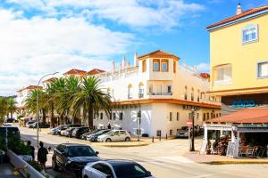 a street with cars parked in front of a building at Hotel Pozo del Duque II in Zahara de los Atunes