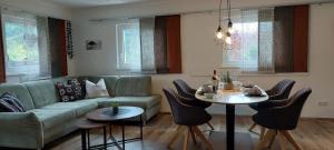 a living room with a couch and a table with chairs at Haus Adrian in Wald am Arlberg