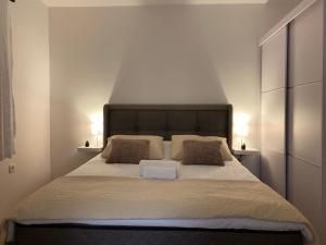 a bedroom with a large white bed with two pillows at Apartmani Kolaković in Arandelovac +19 photos