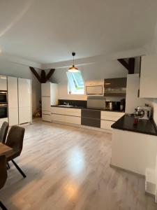 a large kitchen with white cabinets and a wooden floor at 4 Zimmer Design Atelier Wohnung in Goslar