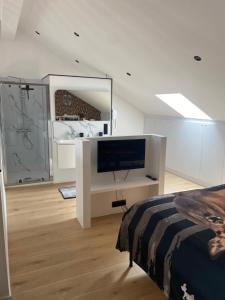 a white room with a bed and a flat screen tv at Hotel Des Ardennes in Verviers