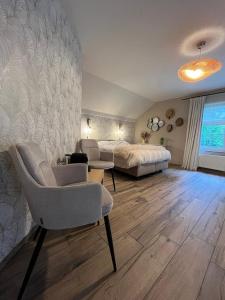a bedroom with a bed and a couch and a chair at L'envie d'ailleurs in Malmedy