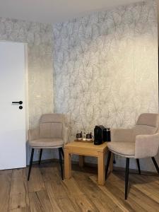 two chairs and a table in a room with a wall at L'envie d'ailleurs in Malmedy +7 photos