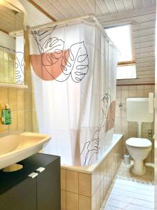 a bathroom with a toilet and a shower curtain at Appartement thématique Art Moderne in Travers