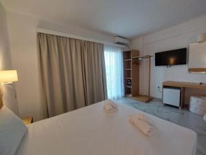a hotel room with a bed and a television at Blue Bay Hotel in Iraklitsa