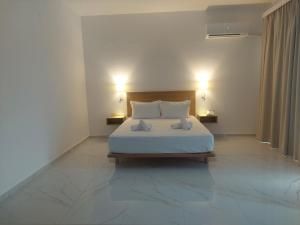 a bedroom with a bed with two pillows on it at Blue Bay Hotel in Iraklitsa
