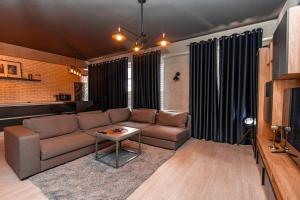 a living room with a couch and a table at Green Park & Lakeview Apartment in Chişinău
