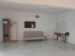 a living room with a couch and a tv at Blue Bay Hotel in Iraklitsa