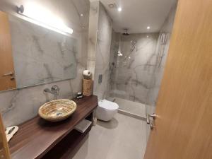 a bathroom with a sink and a shower and a toilet at Blue Bay Hotel in Iraklitsa