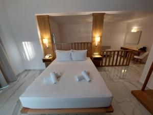 a bedroom with a large white bed with two pillows at Blue Bay Hotel in Iraklitsa