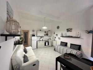 a white living room with a couch and a kitchen at La casa di Andreina in Monterosso al Mare