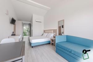 a bedroom with a blue couch and a bed at HOTIDAY Apartment Collection - Desenzano in Desenzano del Garda +39 photos