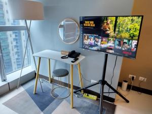 a desk with a phone and a mirror in a room at Uptown Parksuites Tower 1 BGC in Manila