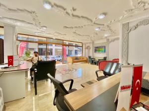 a woman is sitting at a table in a room at Parfe Apart in Trabzon