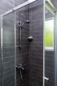 a shower with a glass door in a bathroom at Tranquil Garden Nuwara Eliya in Nuwara Eliya +62 photos