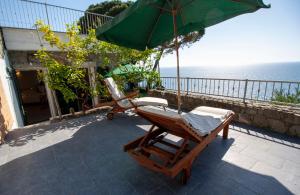 a patio with a chair and an umbrella at Loft Il Castello con terrazza sul mare in Riomaggiore