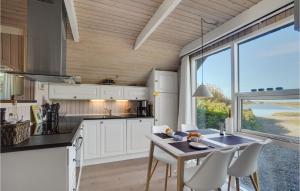a kitchen with white cabinets and a table and chairs at Lovely Home In Vestervig With Wifi in Vestervig