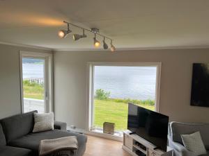 a living room with a couch and a large window at Sjønært feriehus, båt tilgjengelig for leie in Ålesund +13 photos