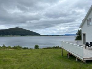 a house with a deck and a view of a lake at Sjønært feriehus, båt tilgjengelig for leie in Ålesund