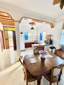 a kitchen and dining room with a wooden table and chairs at Duplex Oualidia surfhouse in Oualidia